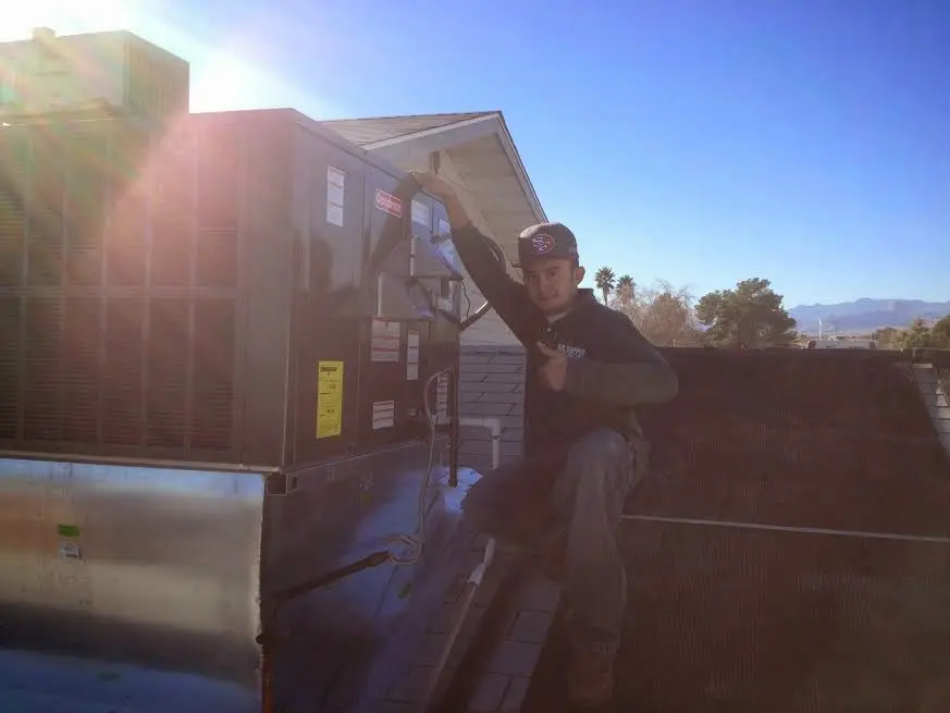 HVAC technician performing Air Duct Cleaning on a rooftop unit in West Vincent